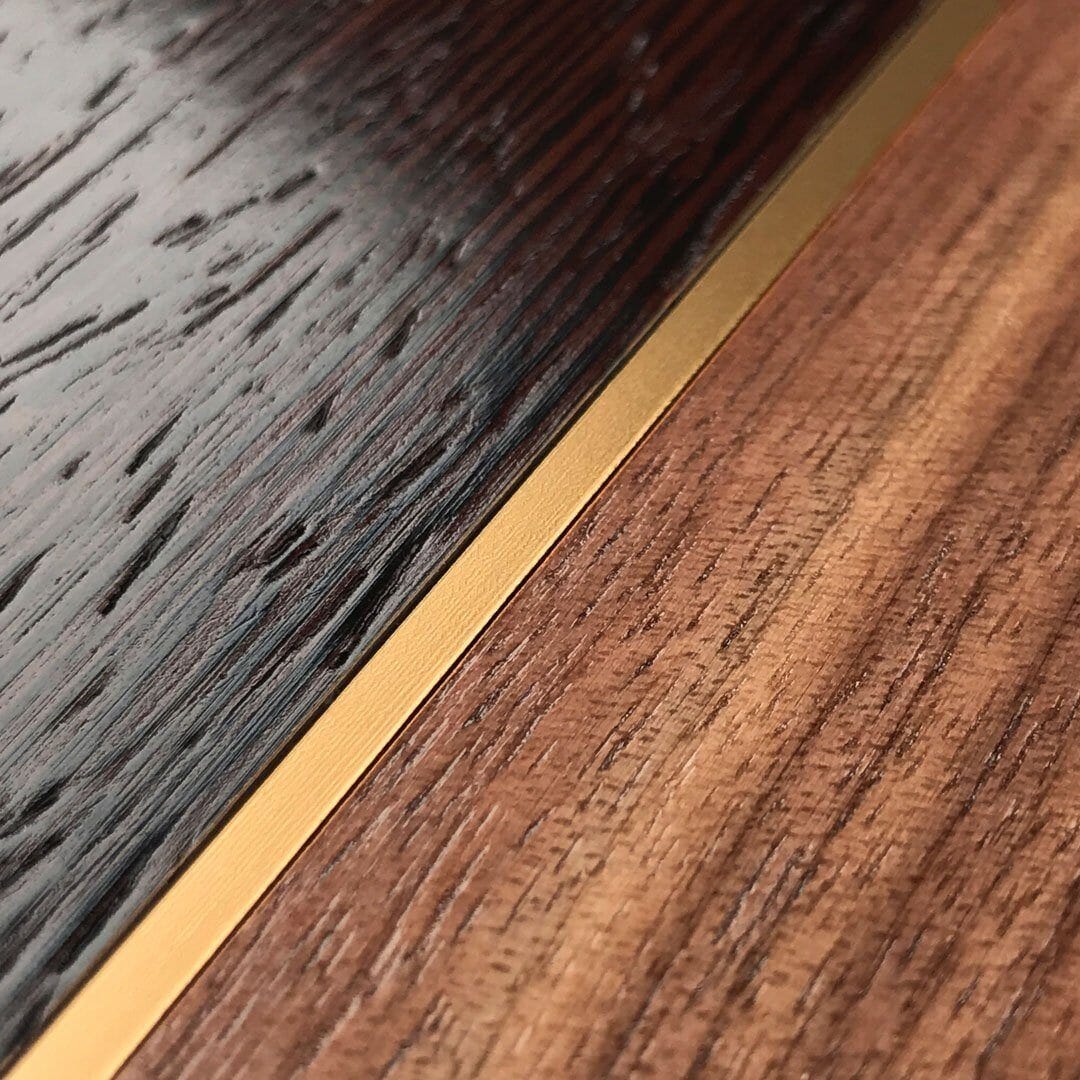 Zoomed in detailed shot of the Alium Walnut, Gold, and Wenge Elegant Wood iPhone 16 Plus MagSafe Case by Keyway Designs