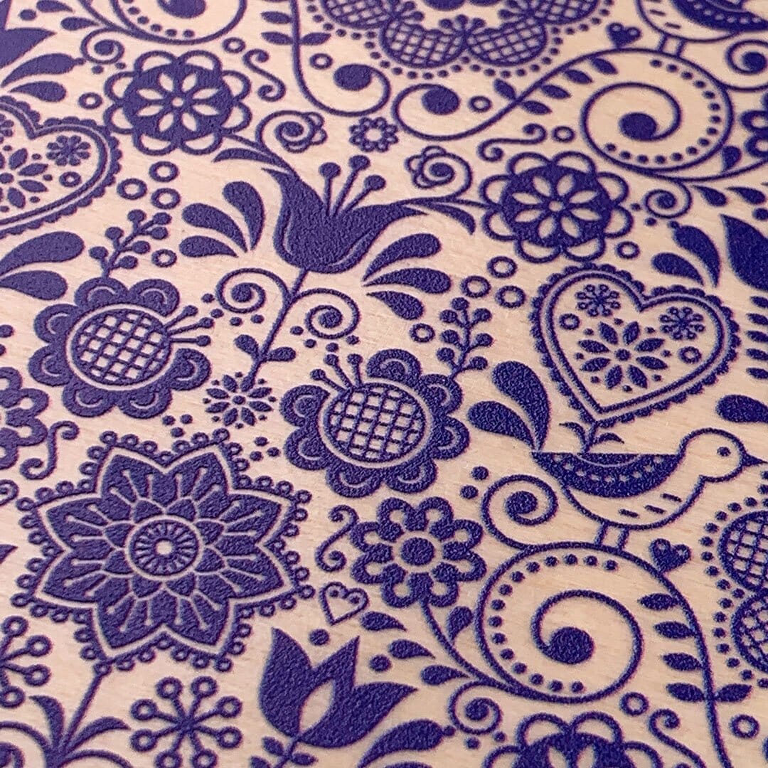 Zoomed in detailed shot of the blue floral pattern on maple wood iPhone 16 Plus MagSafe Case by Keyway Designs