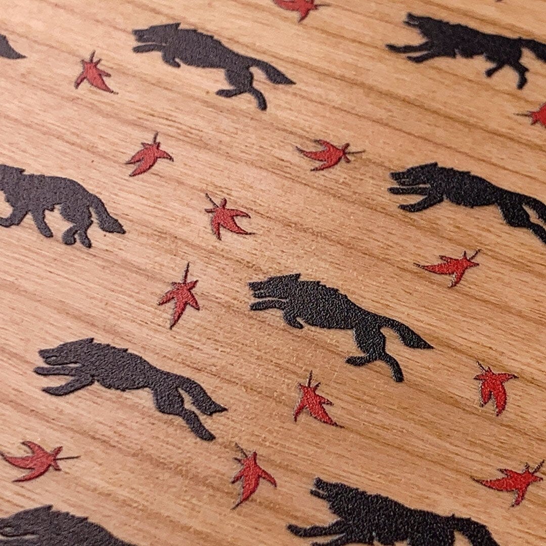 Zoomed in detailed shot of the unique pattern of wolves and Maple leaves printed on Cherry wood iPhone 16 Pro MagSafe Case by Keyway Designs